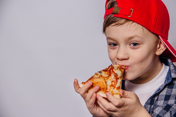 Bambino mangia una fetta di pizza.